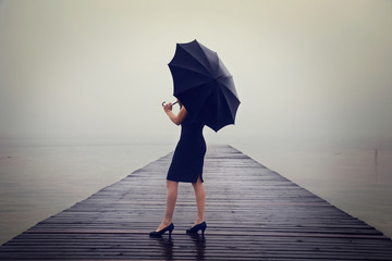 woman with black umbrella looking infinity in a surreal place