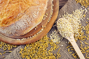 Bread and spoon with grain on the table