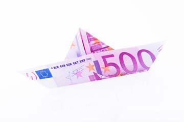 Paper boat made with a 500 euro note on white background