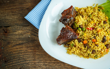 Dish of roast beef with rice and salad leaves