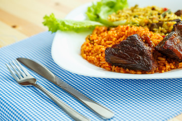 Dish of roast beef with rice and salad leaves