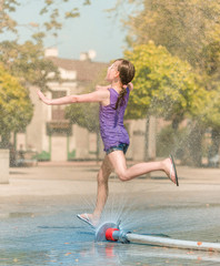Naklejka premium Girl is running through fountains