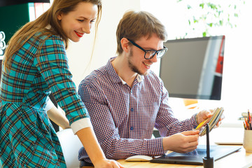 Man and woman looking to a color paint palette at home office