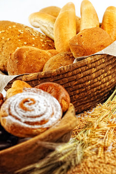 Composition with bread and rolls in wicker basket, combination of pastries for bakery or market