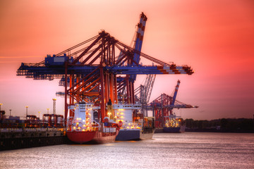 Fototapeta na wymiar Container harbor in Hamburg, Germany. Night shoot with red sky.