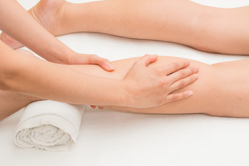 Fototapeta na wymiar Therapist doing massage on woman leg in day spa