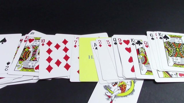 Row of playing cards from which a card with the word happy imprinted on it is slowly revealed, concept for happiness , luck or positive state of mind