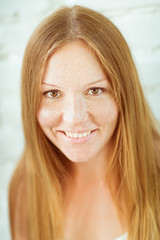 Closeup portrait of adorable red-haired smiling young woman