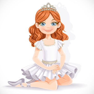 Cute ballerina girl in white dress and tiara sit on floor isolat