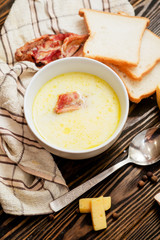 
cheese soup with smoked pork ribs , potatoes, carrots , peppers , spices and bread on the wooden background