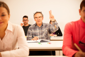 Fototapeta premium Group of people of different age sitting in classroom and attend
