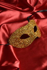 Máscara de carnaval sobre fondo de tela de color rojo