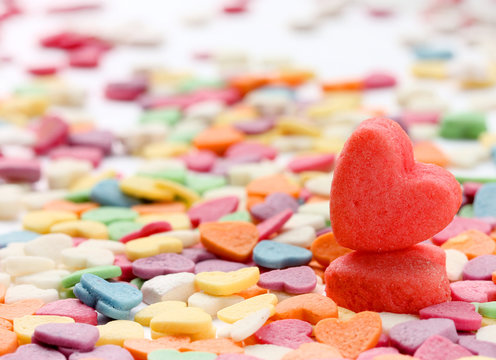 Colored background for Valentine's Day. Sugar sprinkling in a heart shape and cookies. Selective focus