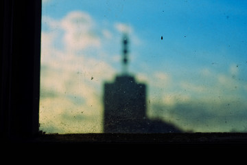 Naklejka na ściany i meble Dirty window glass in slum criminal city district against a skyscraper