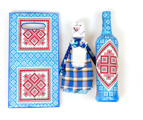 Doll motanka, glass bottle and wooden board decorated with decoupage in Ukrainian style