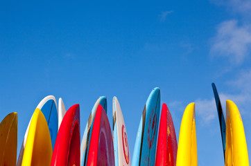 Stack of surfboards with sand on surface