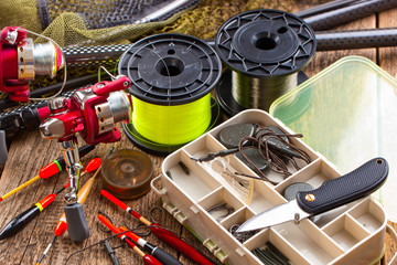 fishing tackle on a wooden table. toned image