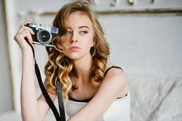 Portrait of a beautiful young blond woman with a camera, lifestyle