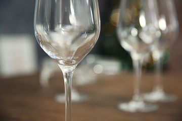 Empty wine glasses on wooden table against blurred background