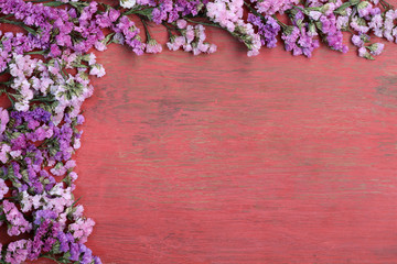 Fototapeta na wymiar Red flowers on a wooden floor.