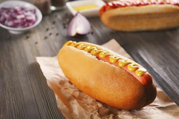 Hot dog on craft paper on wooden background