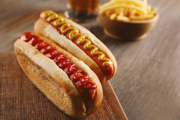 Hot dogs with fried potatoes on cutting board