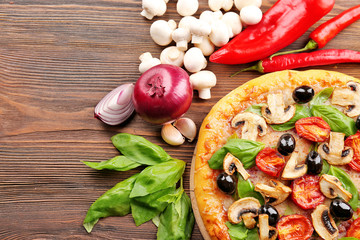Delicious tasty pizza with ingredients on wooden table