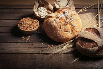 Fresh baked bread, flour and wheat on the wooden background