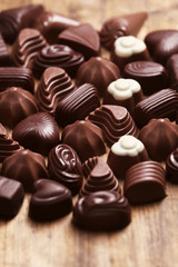 Delicious chocolate candies on wooden background