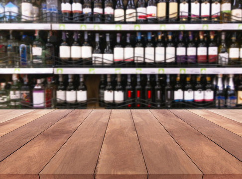 Wood table and wine Liquor bottle on shelf Blurred background