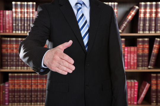 Midsection Of Attorney Offering Handshake