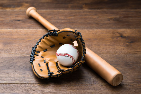 Baseball Glove And Ball With Bat On Table