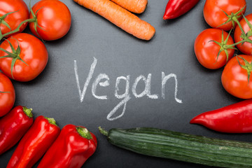 Vegan Written Amidst Fresh Vegetables On Blackboard