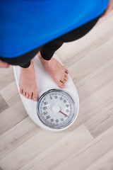 Woman Measuring Weight On Weighing Scale