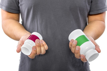Male comparing bottles of medicine or dietary supplements