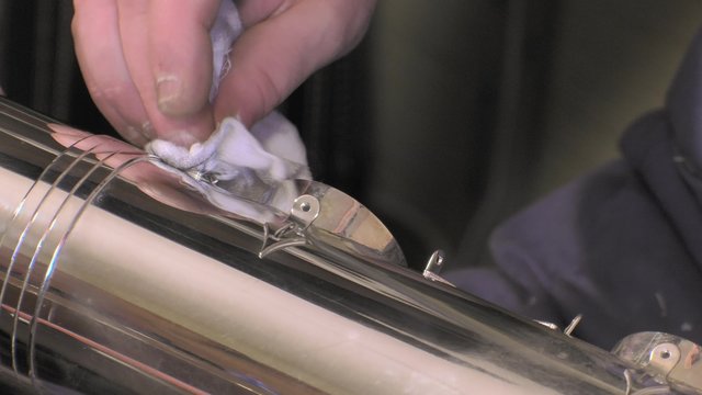 polishing the silver body of the saxophone