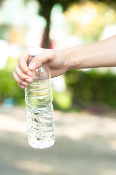 Young people hand holding a bottle of water - hydration concept