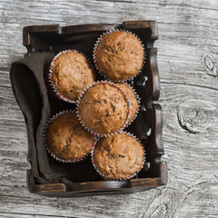 Oatmeal and banana  muffins in vintage tray on rustic light wooden board.
