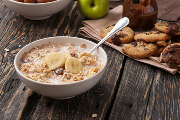 Tasty oatmeal porridge with bananas in white bowl