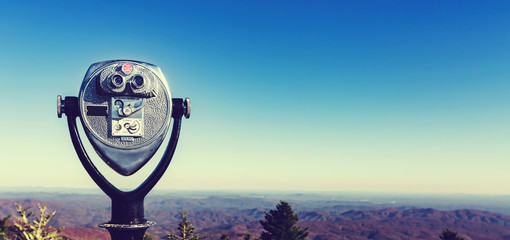Coin-operated binoculars looking out over a mountain landscape - Powered by Adobe