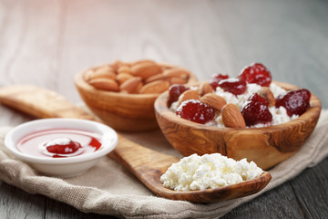 cottage cheese with preserved strawberry in wood bowl on oak table