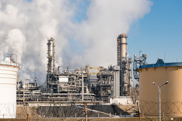 Fototapeta na wymiar oil refinery with smoking chimneys against blue sky
