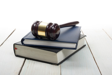 Obraz premium Open law book with wooden judges gavel on table in a courtroom