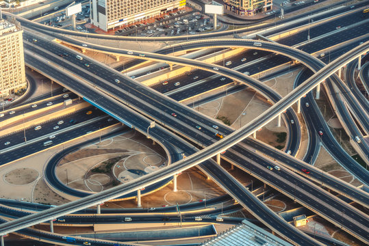 Aerial view of highway junction with little traffic in Dubai, UAE, at sunset. Famous Sheikh Zayed road in Dubai downtown. Transportation and driving concept.