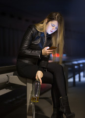 Fototapeta na wymiar caucasian woman drinking alcohol and typing message on street at