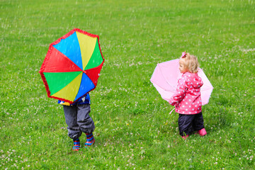 kids with umbrellas outdoors on rainy day