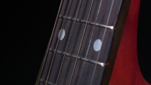 String of acoustic guitar, side view, on black, close up, slow motion