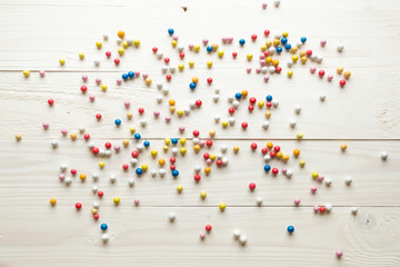 Background of colorful candies lying on white wooden boards