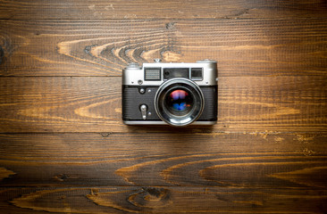 Top view of old camera on wooden background