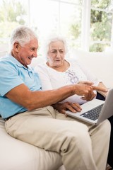 Focused senior couple using laptop